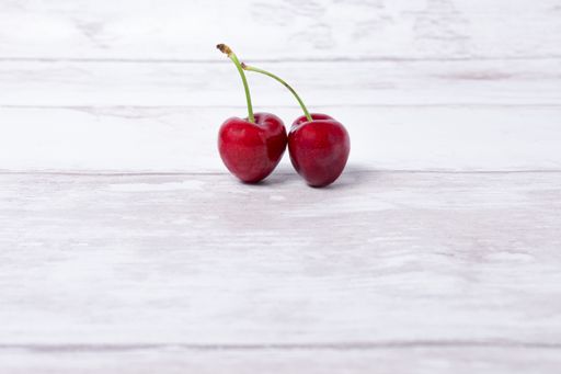 A closeup of two cherries isolated in the center of the image