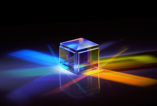 multicolored rays of light reflected by a crystal cube