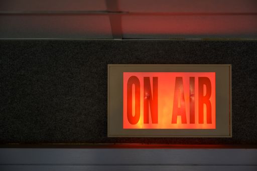 A closeup shot of a red glowing sign that says "ON AIR"