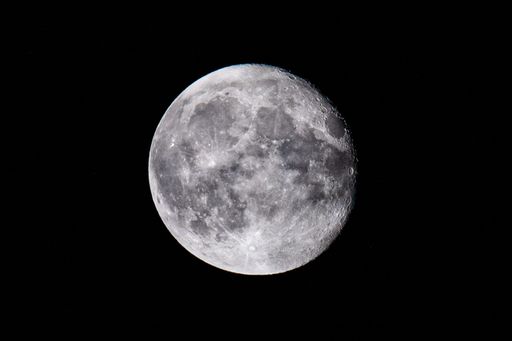 A mesmerizing view of a moon over the dark black sky at night