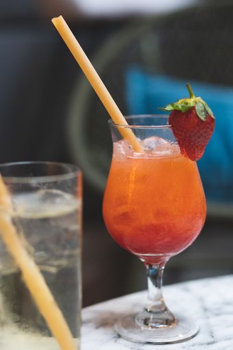 A vertical shot f a cocktail drink with fresh strawberry