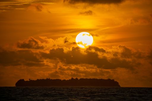 A scenic view of a sunset with cloudy sky reflected in the wate