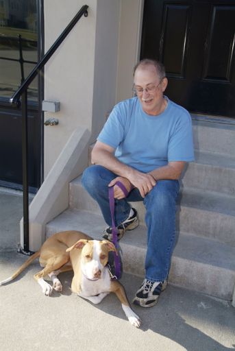 A man sitting on doorsteps with his dog