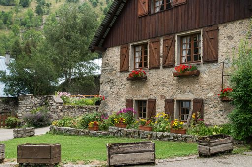 A scenic view of antique stone buildings surrounded by green mountains in Isere, France