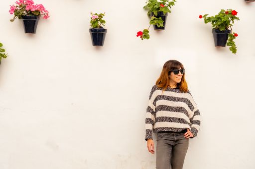 A view of a young tourist in the pots with flowers in the white houses of the town of Nerja, Andalucia, Spain