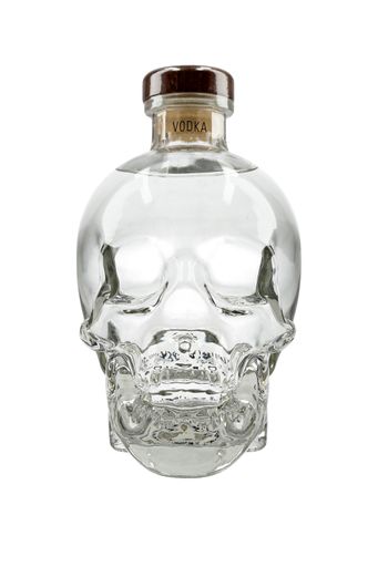 A vertical shot of a skull designed vodka glass bottle isolated on a white background