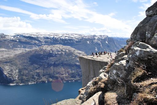 A beautiful shot of high rocky cliffs and mountains with a group of people standing on the edge