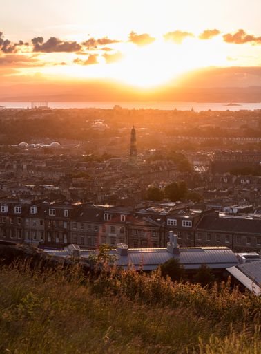 A vertical distant shot of a city view with buildings and houses during sunrise