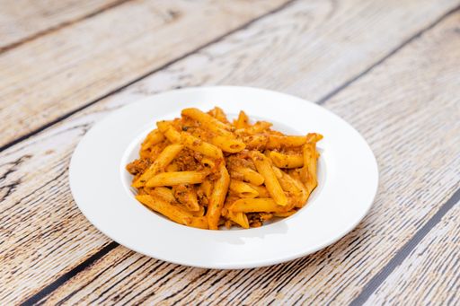 A closeup shot of penne pasta on a white plate