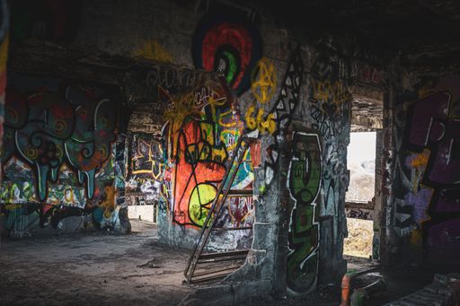 A view of an abandoned old police station covered in graffiti.