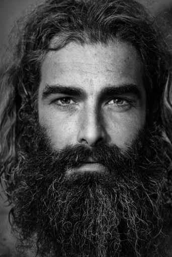 A black and white portrait of a man with long hair and beard