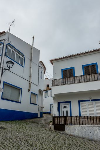 A vertical shot of small cottages in Odeceixe, Portugal, on a cloudy day