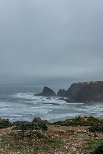 A vertical shot of the seashore on a cloudy day, Odeceixe, Portugal