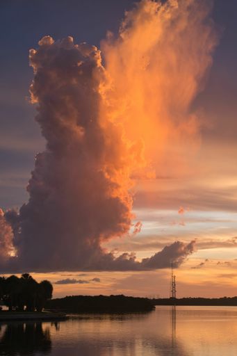 A vertical shot of dramatic clouds over the lake during sunset