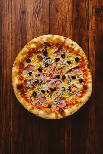 A top view of a pizza on a wooden table