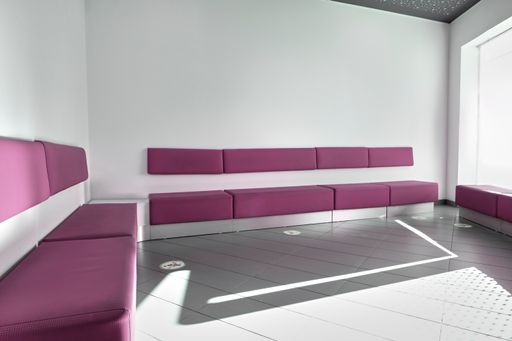 A waiting room of a clinic with purple seats