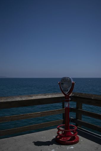 A vertical shot of a tourist seaside telescope captured on a bright day with a clear horizon