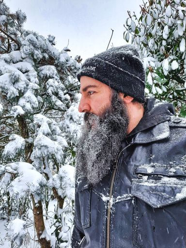 A portrait of the young Caucasian bearded man in the winter forest