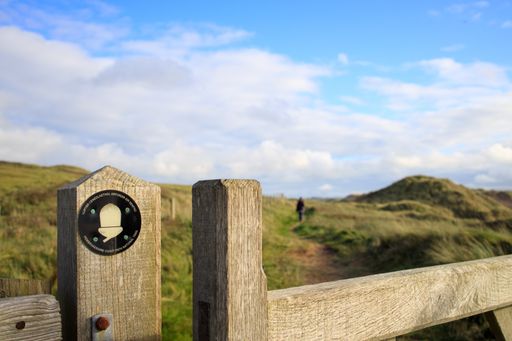 A view of the sign of Pembrokeshire trail on the wooden fence in the field