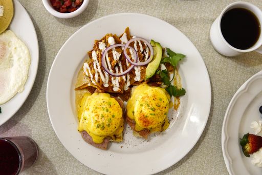 A high angel shot of breakfast with benedict eggs, salad and a cup of coffee