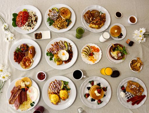 A high angel shot of full breakfast table with omelets, potatoes, and vegetables
