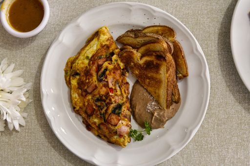 A breakfast served with omelet eggs, sausages and toasts,