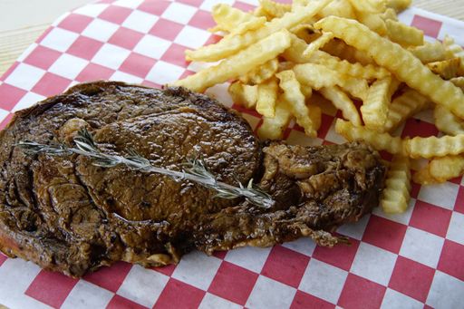 A high angel closeup shot of Delmonico steak and french fries