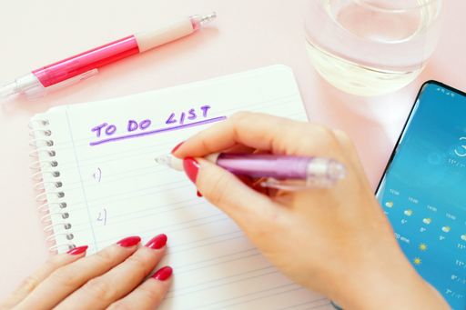 A closeup shot of a woman writing down her "To do list" on the paper
