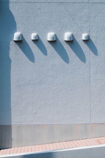 A vertical shot of assorted street wall lights on a white wall