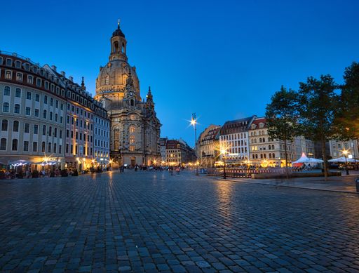 A vertical shot of the Frauenkirche Dresden Church in Germany reflecting on water with a blue sky