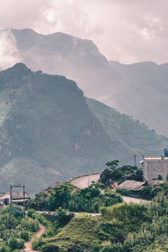 A vertical shot of a road leads to the village in mountains