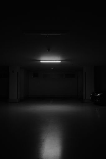 A grayscale vertical shot of underground parking lot