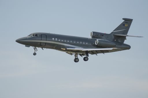 A closeup shot of a gray airplane flying on the clear blue sky background