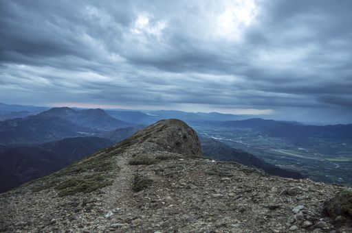 A scenic view of mountains and beautiful cloudscape from a rocky mountain summit
