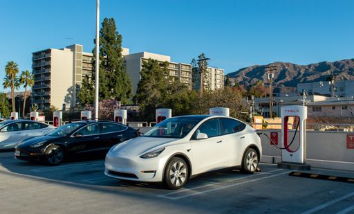 A Tesla charging station with mountains in the background