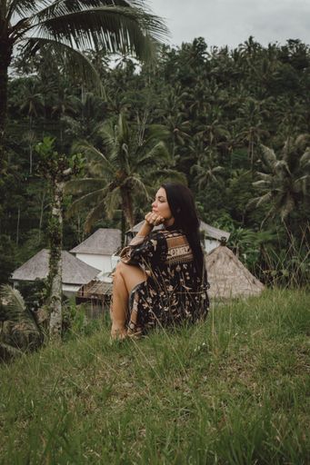 A beautiful young European lady sitting on a hill in tropical Bali, Indonesia