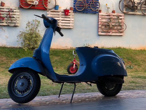 A beautiful view of a blue Vespa outdoors in the street