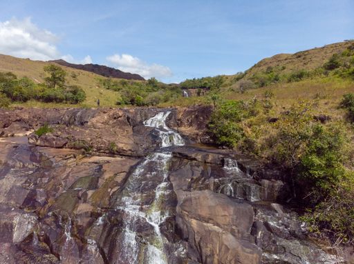 A beautiful photo of a waterfall, rocks and trees in nature on a sunny day