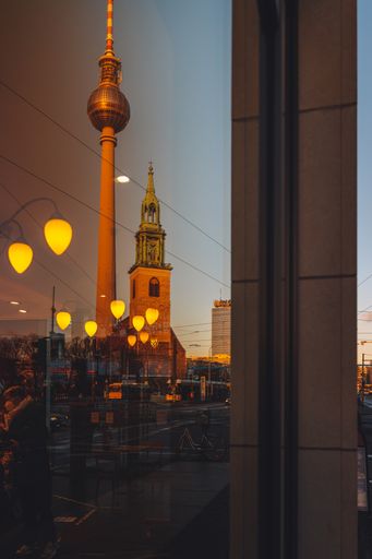 A vertical shot of the Berlin TV Tower with St. Mary's Church.