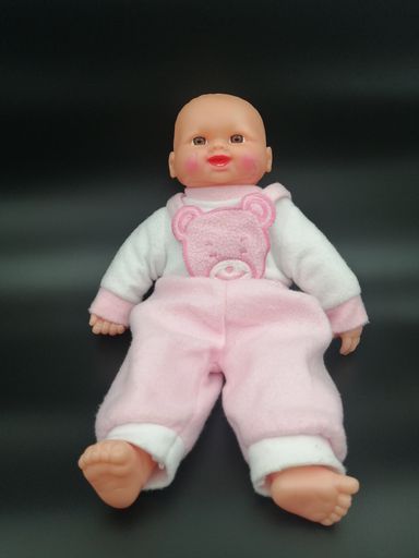 A vertical shot of baby doll toy isolated on black background