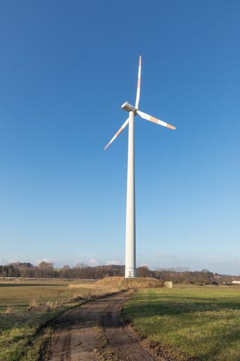 A wind turbine in the field during a sunny day