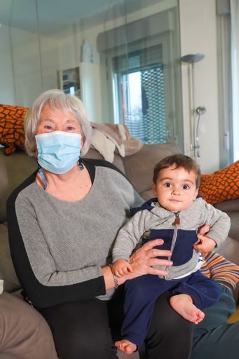 A grandson visiting his grandmother at home and sitting on the sofa