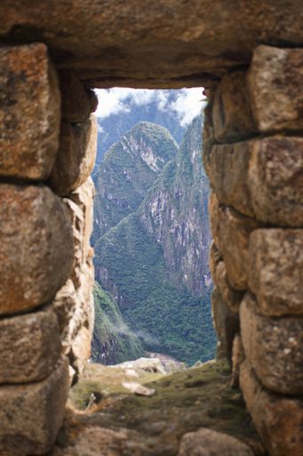 A view of the mountain peak through the stone door in Machu Picchu Aguas Peru