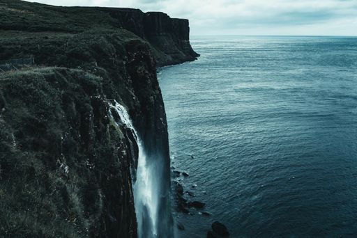 A scenic view of beautiful highlands surrounded by the ocean in the Isle of Skye in Scotland