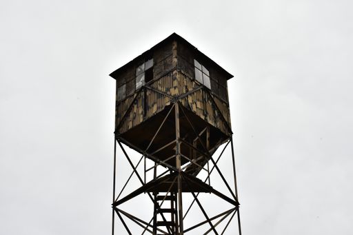 An old wooden watchtower against the cloudy sky