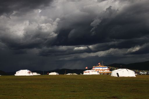 A beautiful shot of tents of a traveling circus under the dark cloudy sky