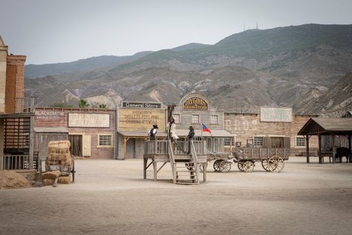 A wild west movie set with some men fighting in the hanging