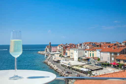 A closeup shot of a glass of drink on the balcony with a view to Piran, Slovenia
