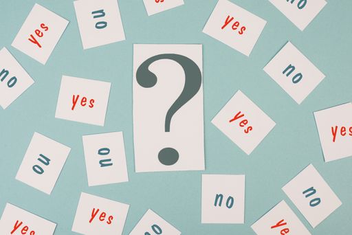 Question mark in the middle, yes and no is standing on papers, looking for an answer, asking for a solution, brainstorming about a decision