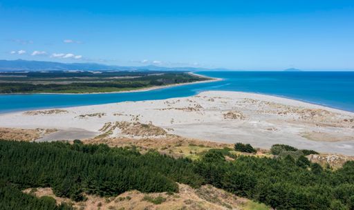 mouth of the manawatu river as it enters the Tasman Sea at Foxton Beach. Looking south, kapiti island in the distance, tararua ranges to the east